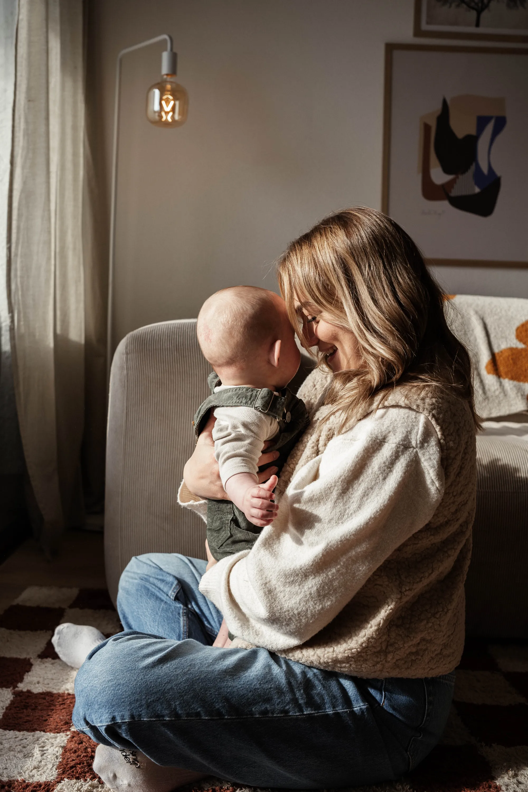 Mutter im Schneidersitz hält ihr Baby