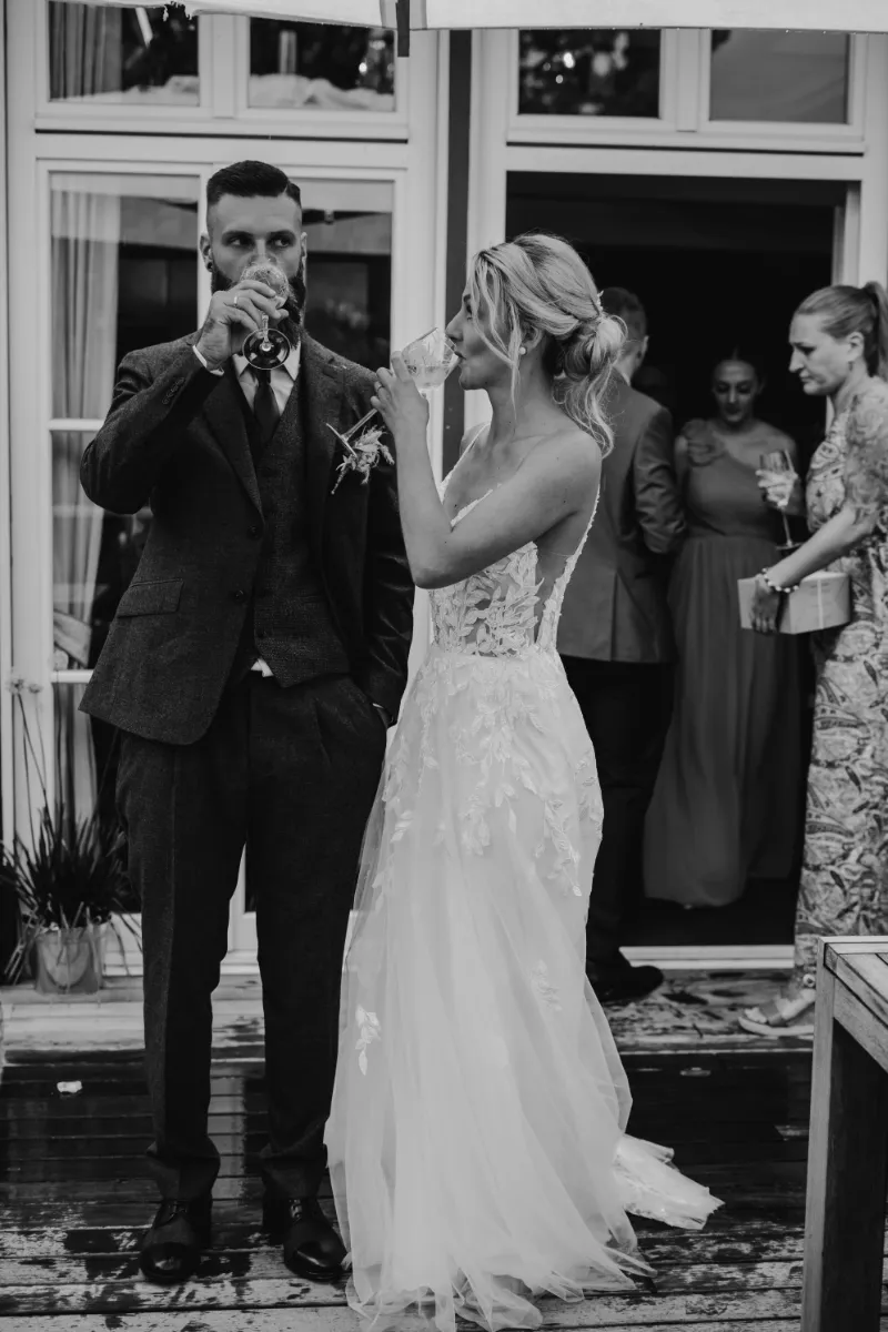 Brautpaar trinkt Sekt vor der Hochzeitslocation