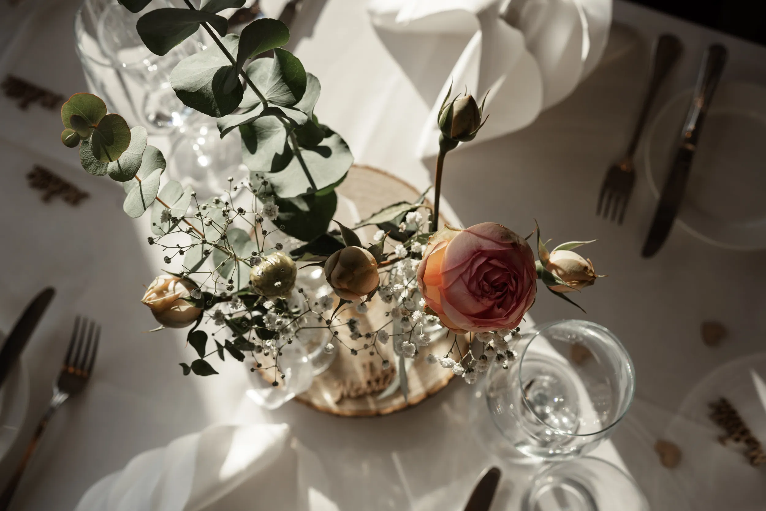 Gedeckte Hochzeitstafel Fokus auf Blumenschmuck mit orangenen Rosen