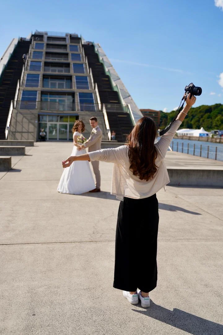 Jacky gibt dem Brautpaar Anweisungen und streckt die Arme von sich